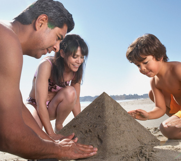 Family building sandcastle at beach